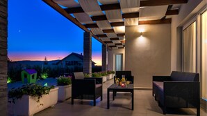 An outdoor patio with two wicker chairs, a table with drinks, and potted plants. - Gorgeous home in Sibenik (Sibenik)