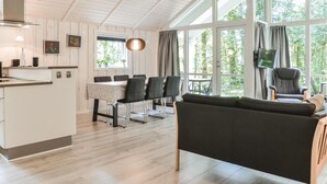 Ett modernt kök med matplats, stora fönster och en mysig sittgrupp.
