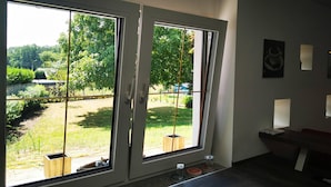 A room with large sliding glass doors leading to a garden.