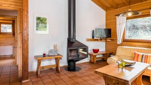 A cozy cabin interior with a fireplace, wooden furniture, and a television. - Reinskopf by Interhome (Schönecken)