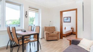 Una habitación con una mesa de comedor y sillas, un sofá, un sillón reclinable y una cama.