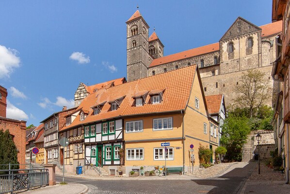 Eine historische Straße mit traditionellen Fachwerkhäusern, einem markanten Kirchturm und Kopfsteinpflaster.