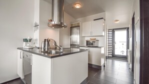 Una cocina moderna con una isla central, electrodomésticos de acero inoxidable y un ventanal grande.