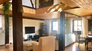 Un salon spacieux avec un canapé, un téléviseur et une bibliothèque.