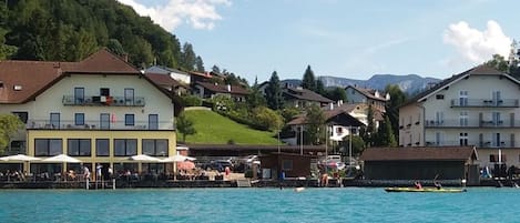 A waterfront hotel with multiple buildings, a dock, and a mountainous backdrop.
