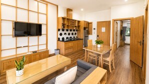 A modern kitchen with wooden cabinets, a black and white backsplash, and a built-in oven. - Minh Hưng Apartment (Da Nang)