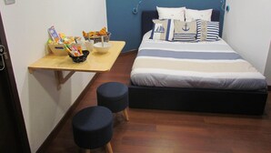 A compact bedroom with a bed, a small table with breakfast items, and two ottomans. - Bed and breakfast SPA - Residence Requirement -2 People -Breakfast included (Saint-Brevin-les-Pins)