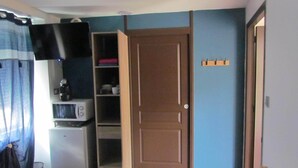 A compact room with a microwave, refrigerator, and open shelving unit. - Bed and breakfast SPA - Residence Requirement -2 People -Breakfast included (Saint-Brevin-les-Pins)