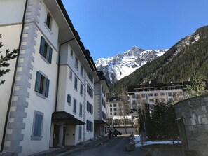 A multi-story hotel with a mountain backdrop, featuring a central courtyard and a view of snow-capped peaks. - Chamonix center, 64m², 6 pers., 2 bedr., parking (Chamonix-Mont-Blanc)