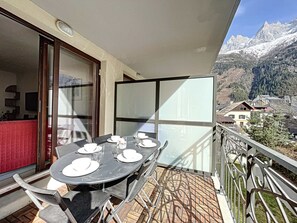A balcony with a table set for four, overlooking a mountainous landscape. - Chamonix center, 64m², 6 pers., 2 bedr., parking (Chamonix-Mont-Blanc)