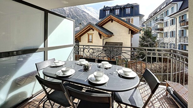 A dining table set for four on a balcony with a mountain view. - Chamonix center, 64m², 6 pers., 2 bedr., parking (Chamonix-Mont-Blanc)