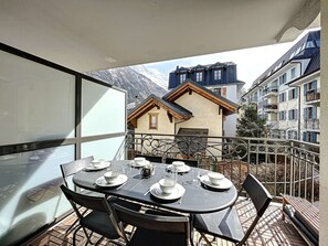 A dining table set for four on a balcony with a mountain view. - Chamonix center, 64m², 6 pers., 2 bedr., parking (Chamonix-Mont-Blanc)