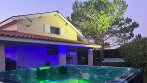 A house with a hot tub and a tree in the backyard.