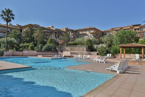 Una piscina al aire libre de temporada, sillones reclinables de piscina