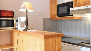 Eine kleine Küche mit Mikrowelle, Kaffeemaschine und Geschirrspüler.