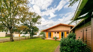 A house with a garden, a large tree, and a fence. - Bright house on large garden near beaches/town center/2 bicycles available (Soulac-sur-Mer)