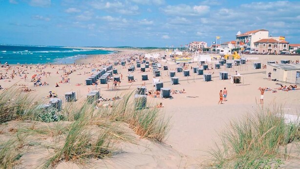 A beach with numerous beach huts and a building in the background. - Bright house on large garden near beaches/town center/2 bicycles available (Soulac-sur-Mer)