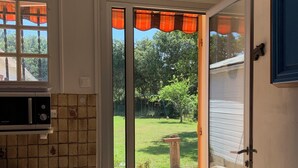 A kitchen with a sliding glass door leading to a backyard. - Bright house on large garden near beaches/town center/2 bicycles available (Soulac-sur-Mer)