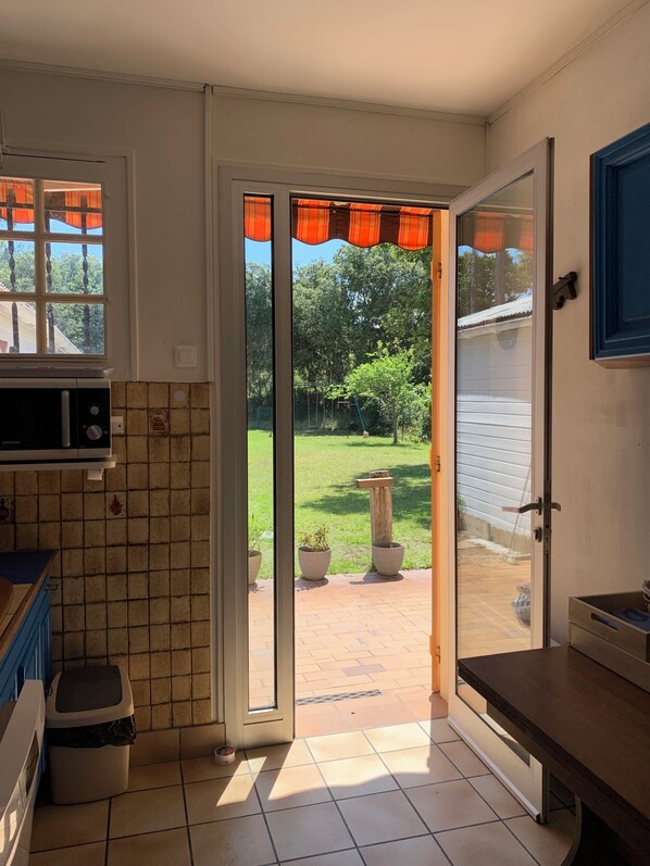 A kitchen with a sliding glass door leading to a backyard.