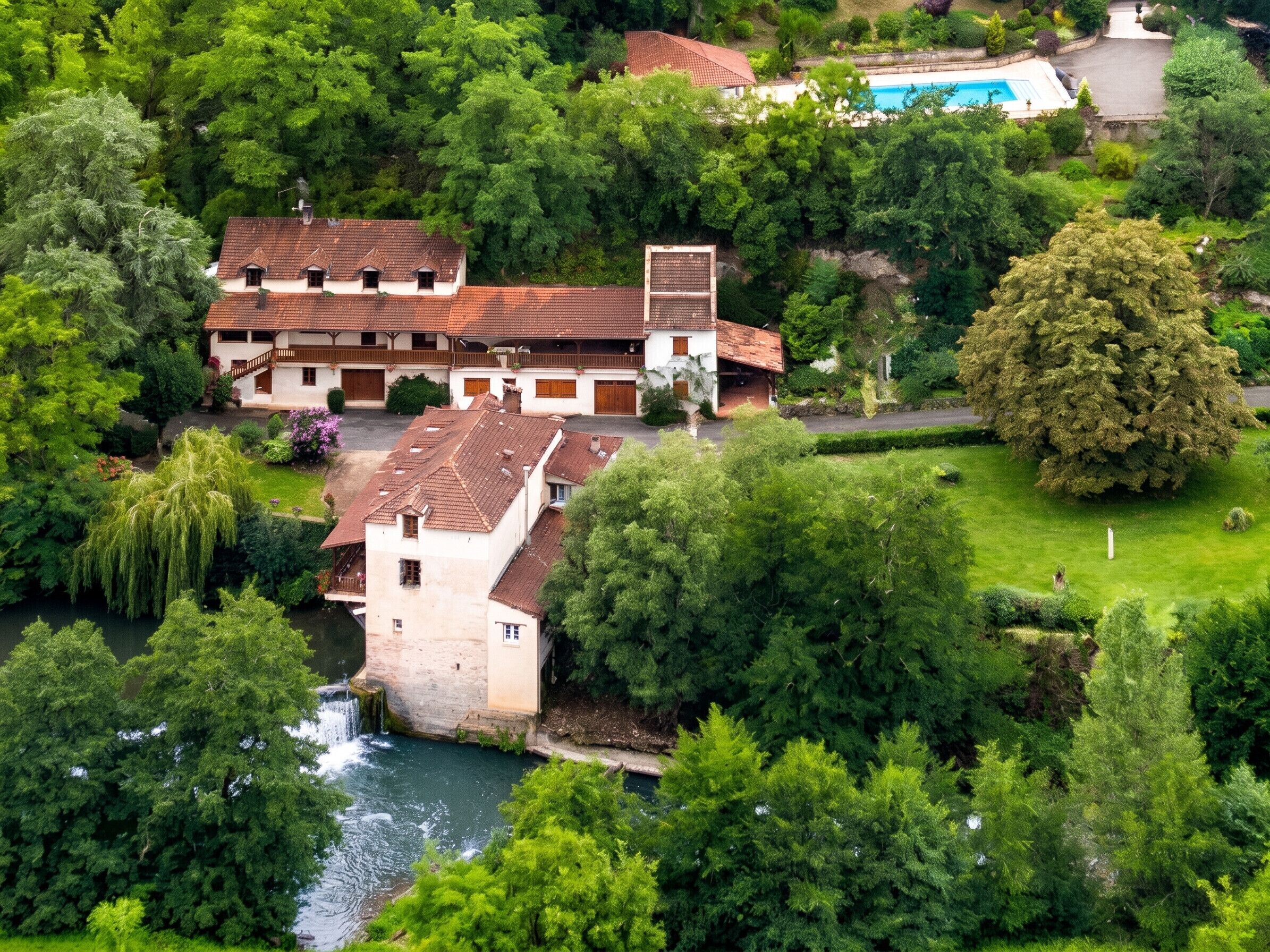 Un vaste domaine doté d’une piscine, d’une cascade et d’une végétation luxuriante.