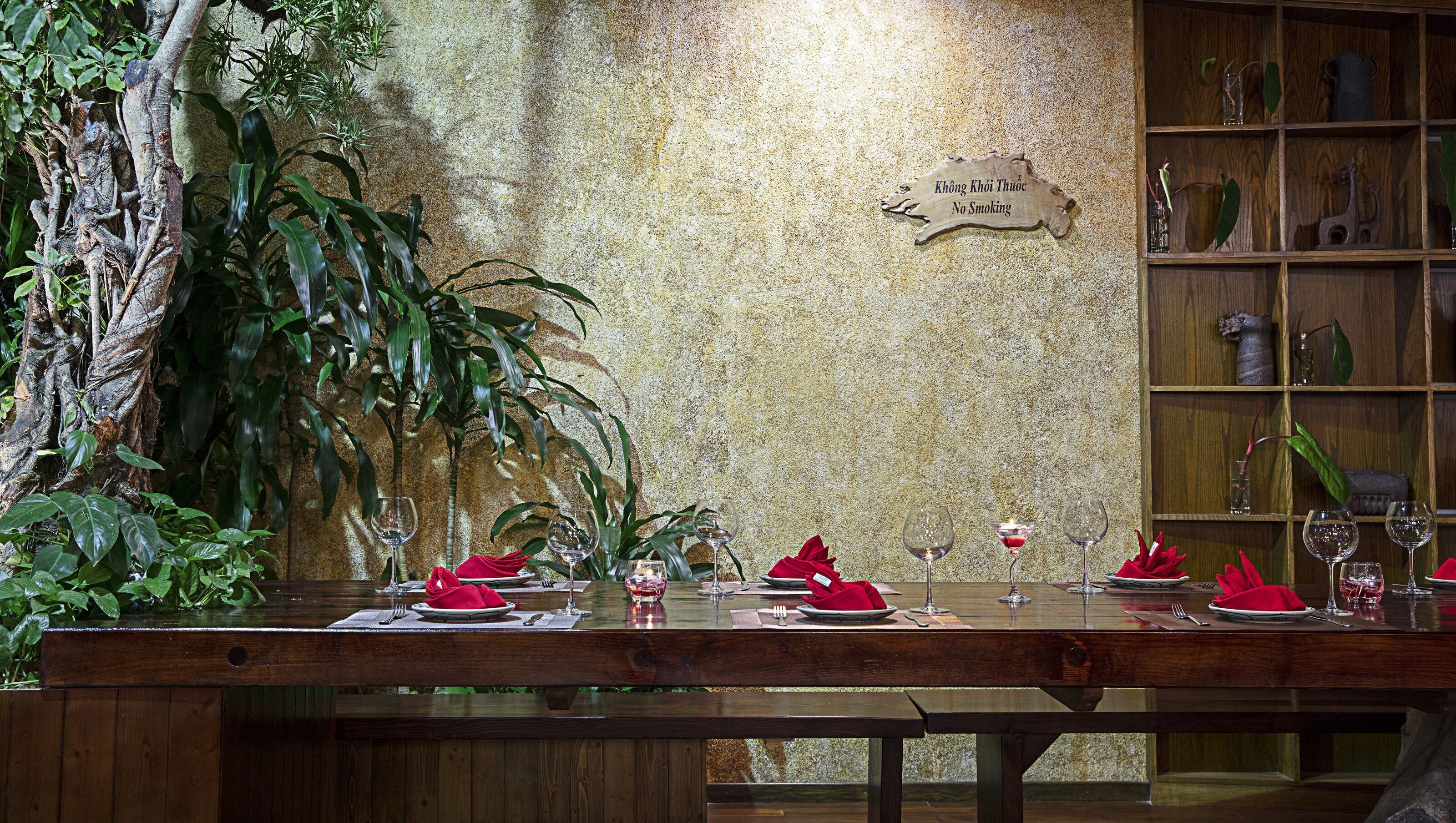 Ein Restaurant mit Holztisch, gedecktem Esstisch, einem Rauchverbot-Schild an der Wand und einem Regal mit Dekoration.