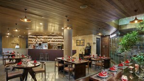 Un restaurant au décor intérieur en bois, avec des tables rondes et des serviettes rouges.