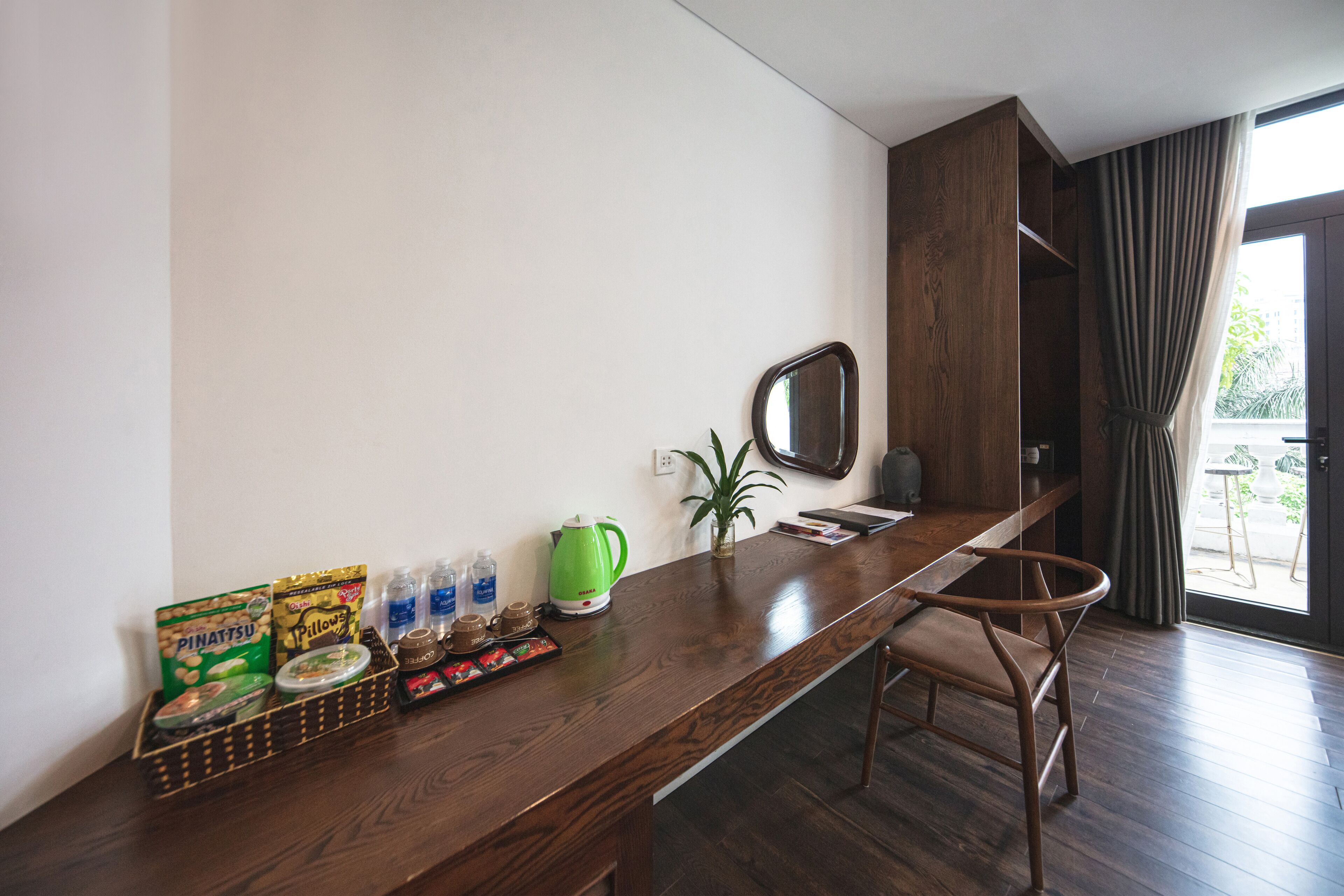 A modern kitchen with a wooden countertop, a green kettle, and a chair.