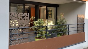 A balcony with a metal railing, potted plants, and a view of the interior of a building. - Apartment, Le Saint Simon rated 3 stars (Aix-les-Bains)