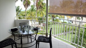 Enjoy dining al fresco with a view of the lush garden and surrounding buildings from this balcony.