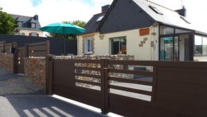 A gated entrance to a building with a stone wall and a wooden gate.