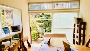 Een kamer met een houten tafel, twee stoelen, een laptop, een boekenplank en een bordje met de tekst 'Vanguard'.