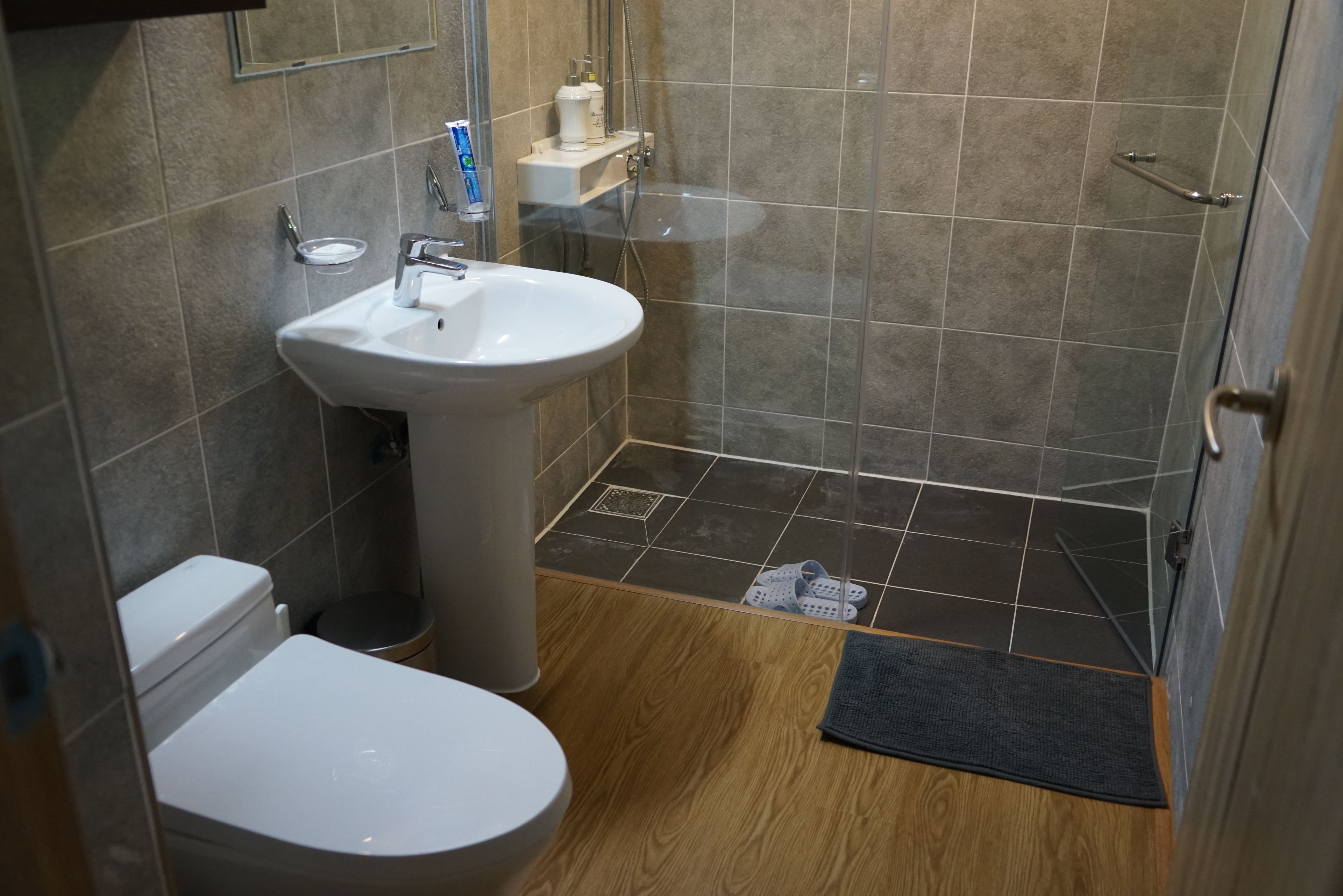 Un baño con lavamanos blanco, inodoro y zona de ducha.