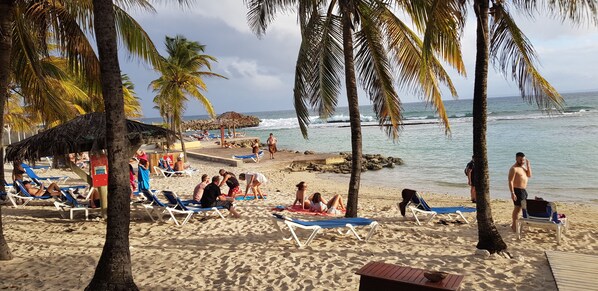 Rannalla, aurinkotuoleja, rantapyyhkeitä