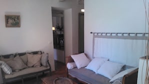 A living room with a sofa, a wooden table, and a bed with a canopy.
