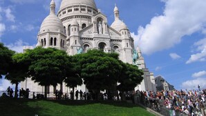 A large, white, domed building with multiple towers and statues, surrounded by a crowd of people. - Cheap Paris. New apartment in town house near the center.   (Seine-St-Denis)