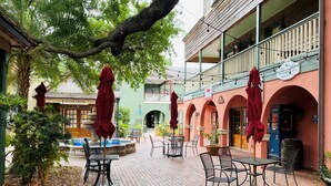 A courtyard with outdoor seating, a fountain, and a building with a sign reading 'St. George's Registry.' - Summer Pool Retreat Near Vilano Beach (St. Augustine)