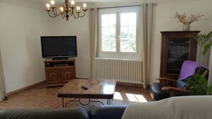 A living room with a TV, wooden cabinet, and a large window. - Provence - Detached house with private pool (Aubignan)