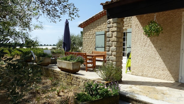 A stone building with a tiled roof, a wooden table and bench, and potted plants. - Provence - Detached house with private pool (Aubignan)