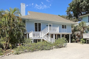 A two-story house with a balcony and a covered porch.