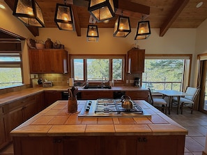 Enjoy cooking in this well-equipped kitchen with a gas stove, ample counter space, and a large window offering scenic views.