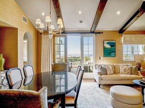A dining area with a round table, chairs, and a chandelier. There is a sofa and ottoman in the background. - Terranea Luxury Luxury Villa - views of stunning sea, Catalina and golf course (Rancho Palos Verdes)