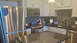 A modern kitchen with a central island, stainless steel appliances, and pendant lighting. - Pet friendly- 1/2 block from beach Seaside Heights/Seaside park - ocean views.  (Seaside Heights)