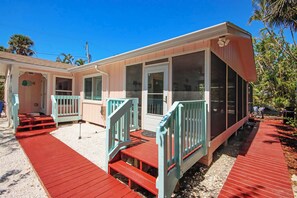 A row of two-story beach cottages with red wooden decks and light blue railings.
