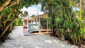 A house with a porch, surrounded by tropical vegetation.