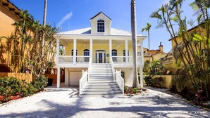 A two-story building with a white exterior, a central entrance with a staircase, and a balcony on the upper floor. - Spacious 5BR Captiva Retreat with Private Pool, Spa & Game Room (Captiva)