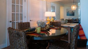 Un coin repas avec une table ronde, des chaises, une lampe et un miroir.