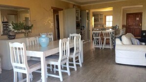A spacious living room with a dining area, a kitchen, and a cozy seating area.