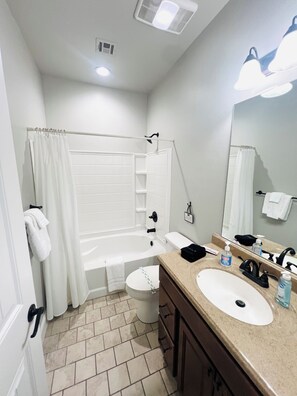 Un baño con bañera, inodoro y dos lavabos.