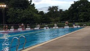 A swimming pool with multiple lanes, surrounded by a fence and trees. - Donmueang Place Hotel (Bangkok)