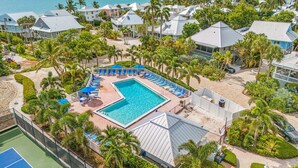 A resort with a swimming pool, tennis courts, and beachfront views.